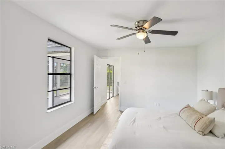 Bedroom featuring light wood finished floors, baseboards, and ceiling fan