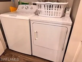 Laundry room with dark wood-style floors and separate washer and dryer