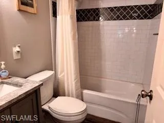 Full bath with vanity, shower / bath combination with curtain, and a textured wall