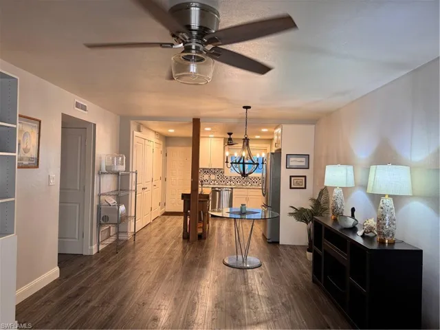Kitchen with dark wood-style floors, stainless steel refrigerator, recessed lighting, a ceiling fan, and pendant lighting