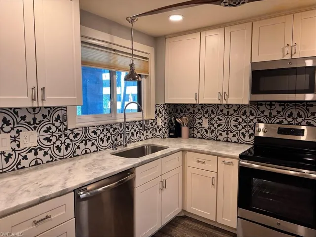 Kitchen featuring stove, white cabinetry, dishwasher, and recessed lighting