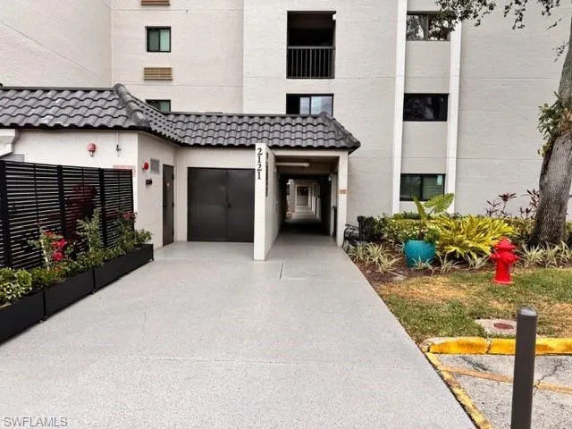 View of exterior entry with concrete driveway, stucco siding, and a garage