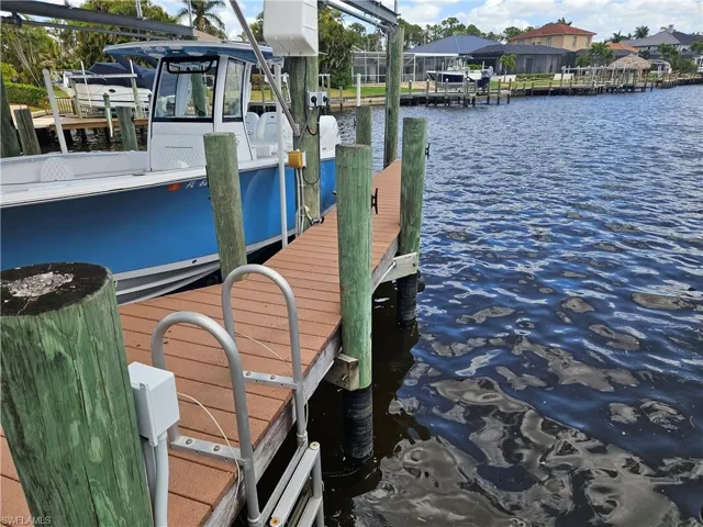 View of dock featuring boat lift and a water view