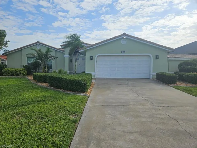 Ranch-style house featuring a tiled roof, stucco siding, a front lawn, an attached garage, and concrete driveway