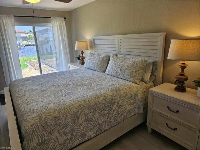 Bedroom featuring access to exterior, wood finished floors, and a textured wall