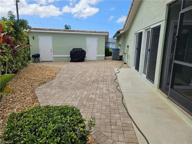 View of patio with grilling area and an outdoor structure