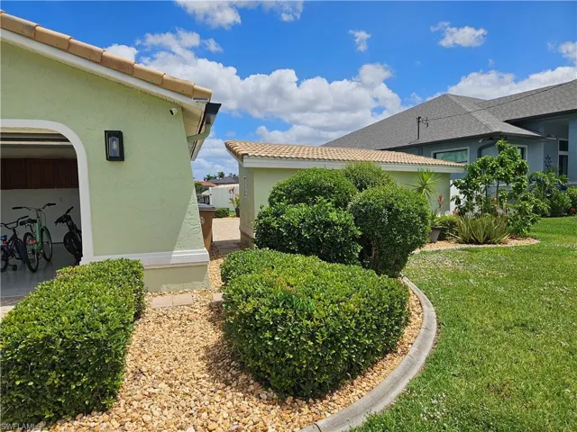 View of side of home featuring stucco siding and a yard
