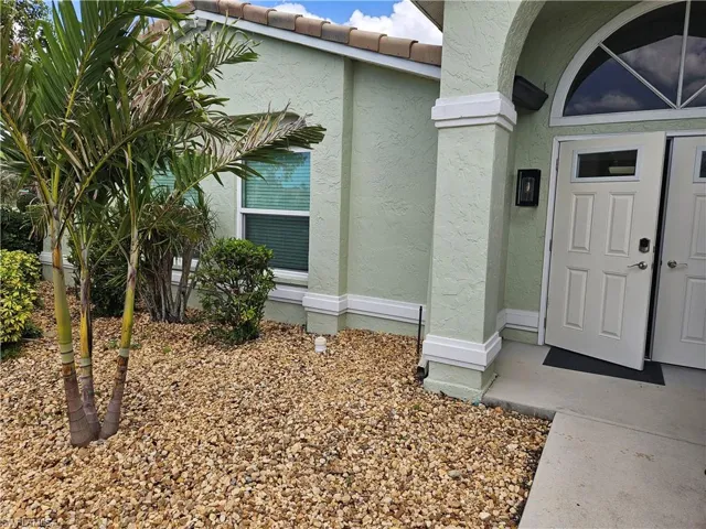 Property entrance with a tiled roof and stucco siding