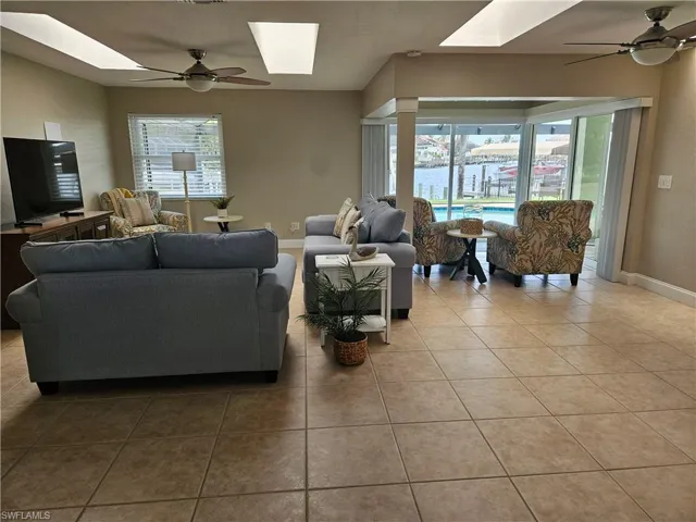 Living room featuring a wealth of natural light, ceiling fan, and a skylight