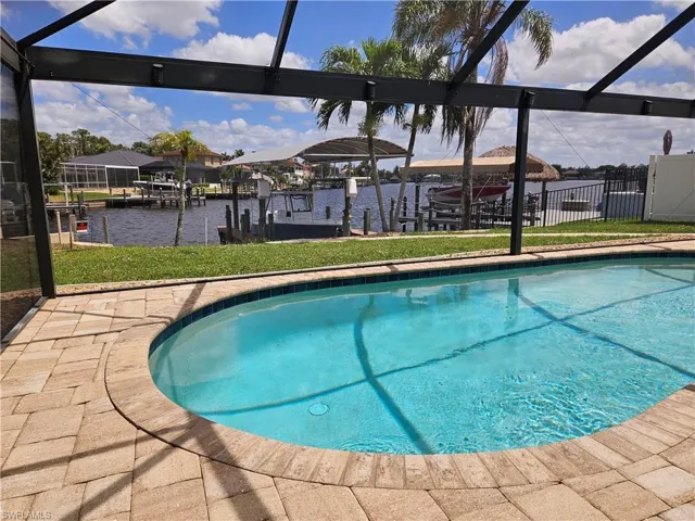 Pool featuring a yard, a lanai, a water view, and a boat dock