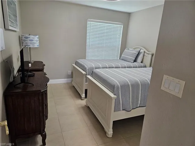 Bedroom featuring baseboards and light tile patterned floors