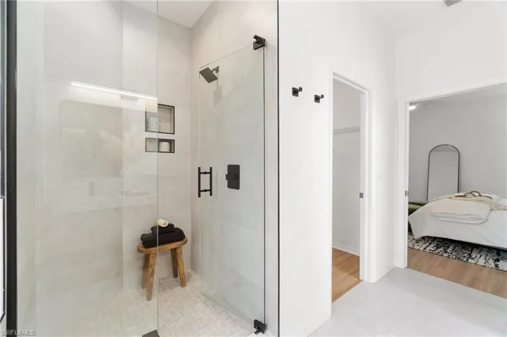 Spacious walk-in shower with new fixtures and glass door