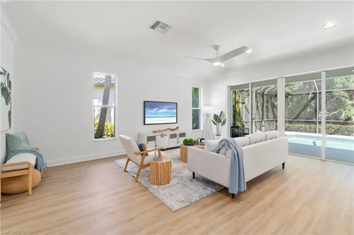 Main living area is filled with natural light and sliders open up leading out to the pool with preserve views
