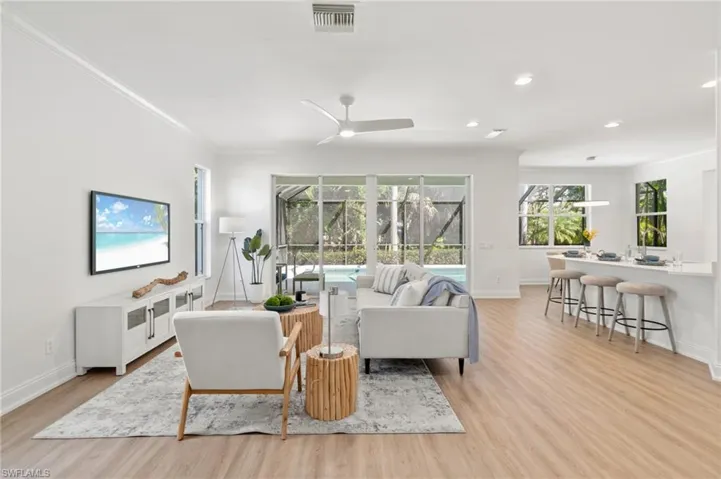 Main living area is filled with natural light and sliders open up leading out to the pool with preserve views