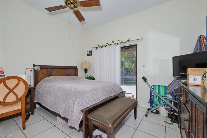 Bedroom with access to exterior, ceiling fan, and light tile patterned floors