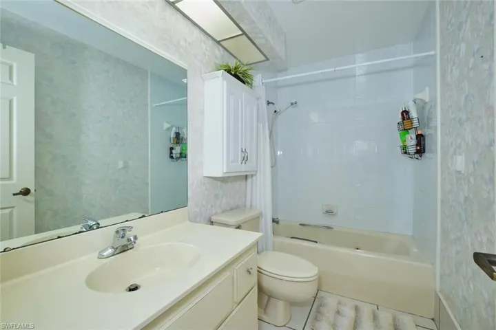 Full bathroom featuring vanity, toilet, tile patterned floors, and tiled shower / bath