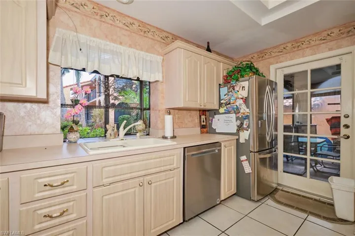 Kitchen featuring appliances with stainless steel finishes, light tile patterned floors, and sink