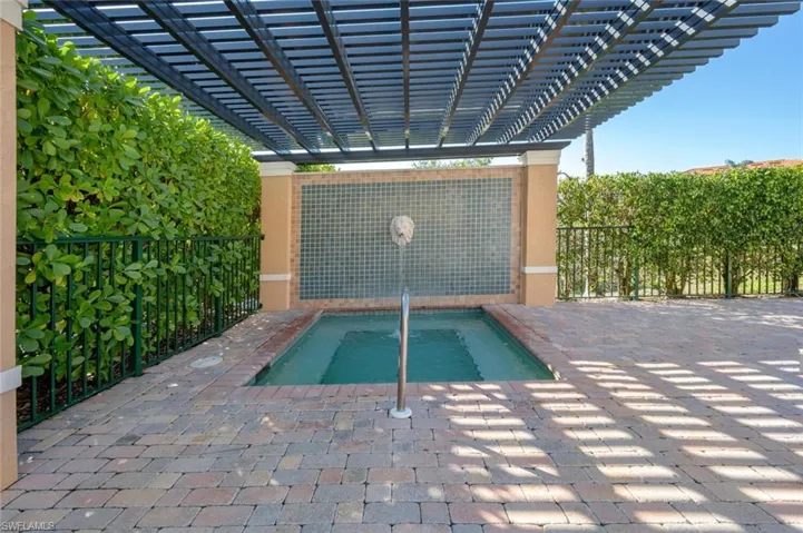 View of pool with fence, a pergola, and a patio