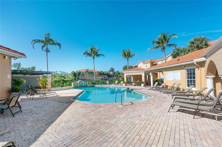 Community pool with a patio area and fence