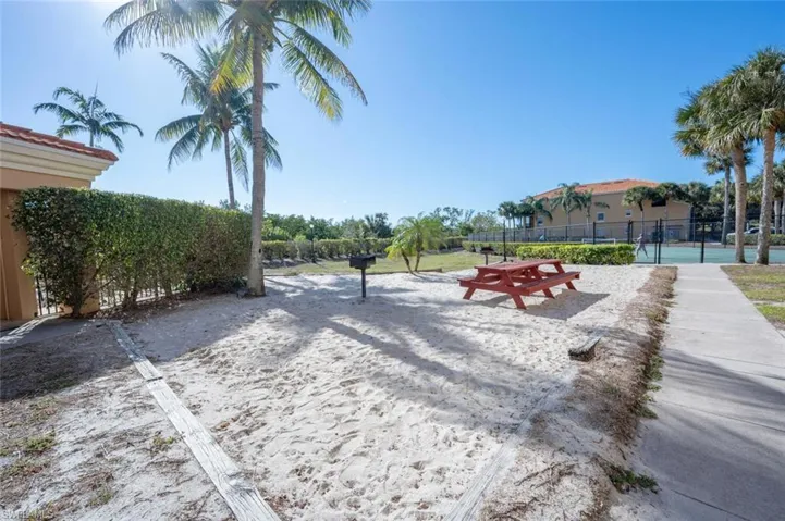 View of home's community with volleyball court and fence
