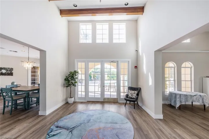Foyer featuring wood finished floors, beamed ceiling, and french doors