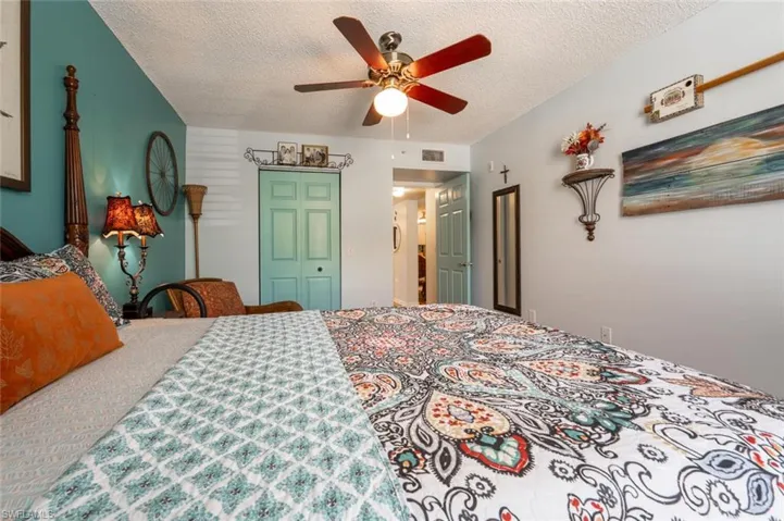 Bedroom with a textured ceiling, ceiling fan, a closet, and visible vents