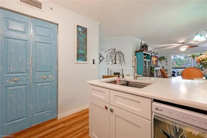 Kitchen with light countertops, visible vents, white cabinetry, a sink, and light wood-type flooring