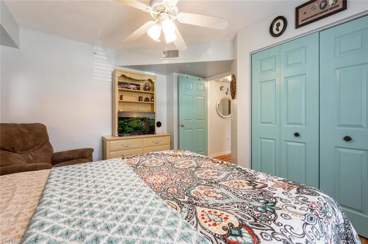 Bedroom featuring a closet, visible vents, ceiling fan, and a textured ceiling