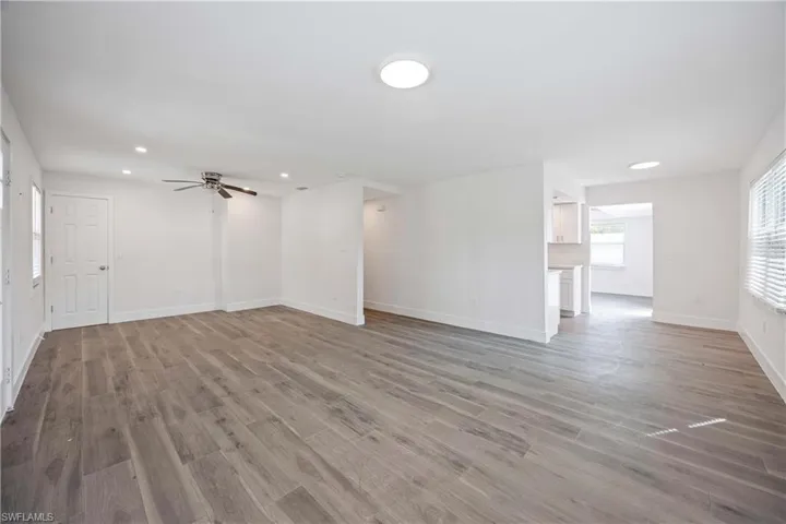 Unfurnished living room featuring baseboards and wood finished floors