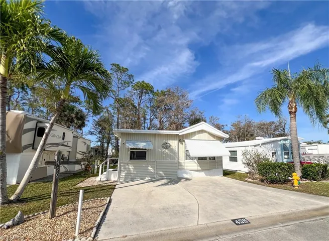 Manufactured / mobile home with board and batten siding and concrete driveway