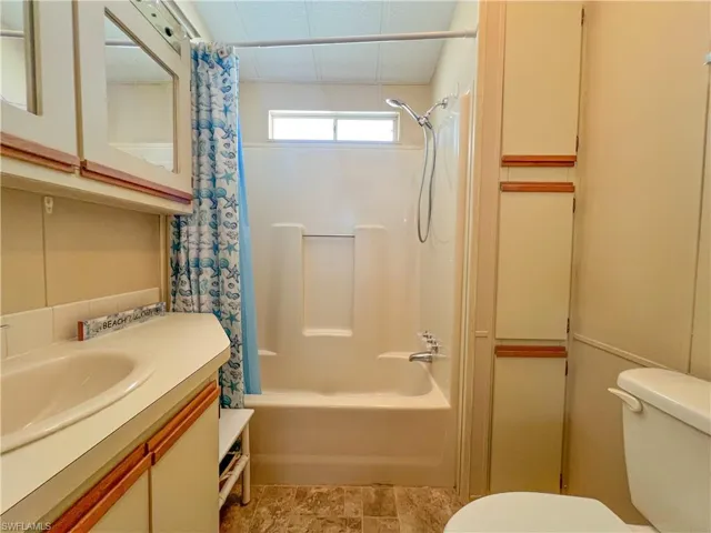 Full bath with shower / bath combination with curtain, vanity, and toilet