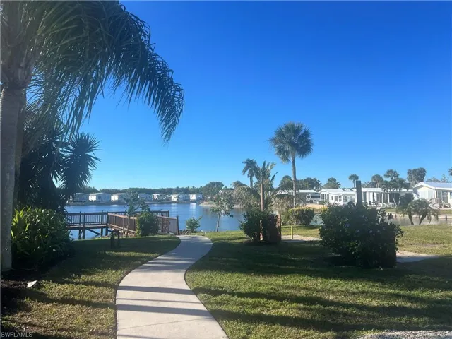 View of property's community with a lawn and a water view