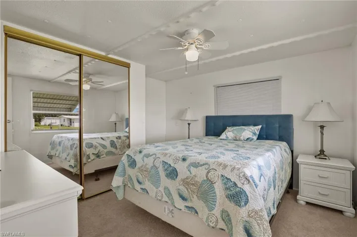 Carpeted bedroom with a textured ceiling, a closet, and ceiling fan