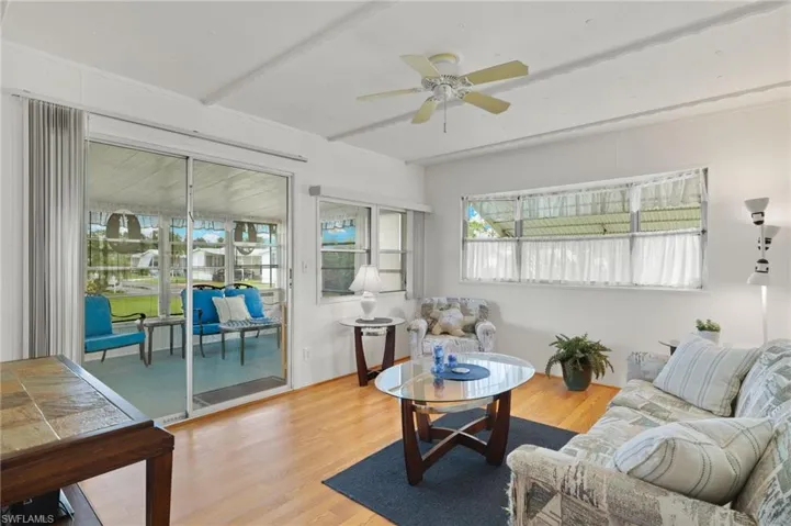 Living room with ceiling fan and hardwood / wood-style flooring