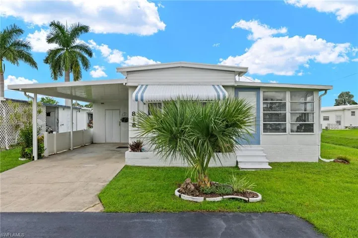 View of front facade with a front lawn and a carport