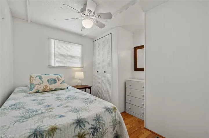 Bedroom with a textured ceiling, a closet, ceiling fan, and light wood-type flooring