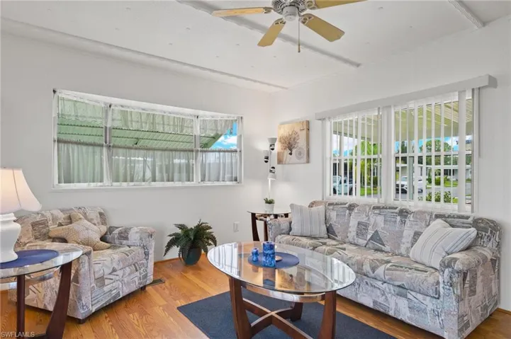 Living room featuring ceiling fan, a healthy amount of sunlight, and hardwood / wood-style flooring