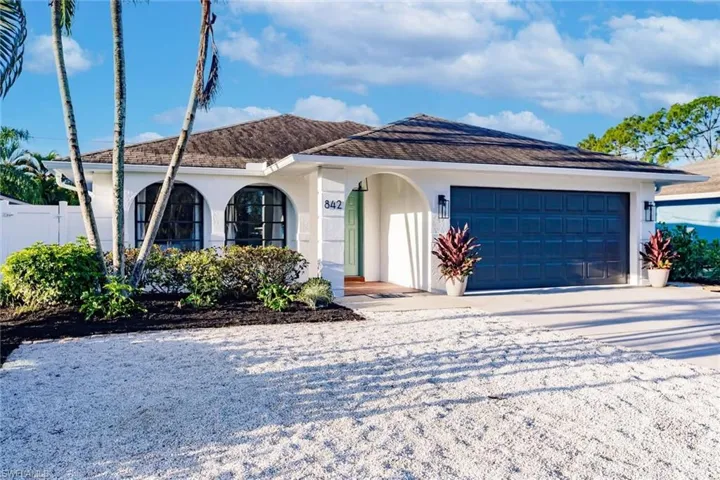 View of front of home with stucco siding, concrete driveway, and an attached garage