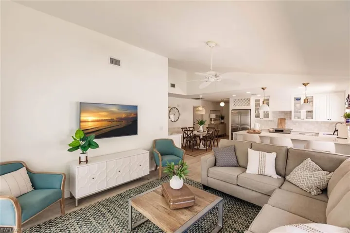 Living room featuring ceiling fan and vaulted ceiling
