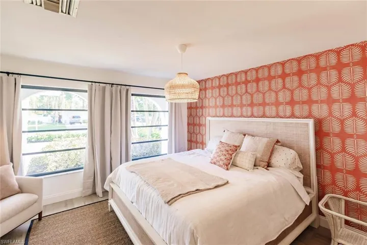 Bedroom featuring wallpapered walls and baseboards