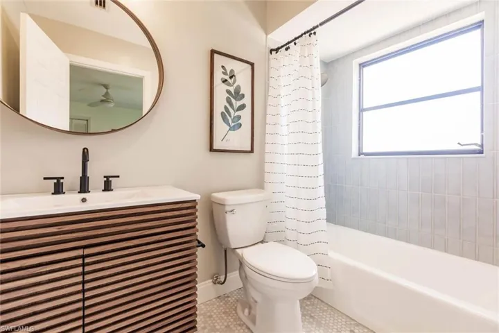 Bathroom featuring vanity, shower / tub combo, and tile patterned flooring