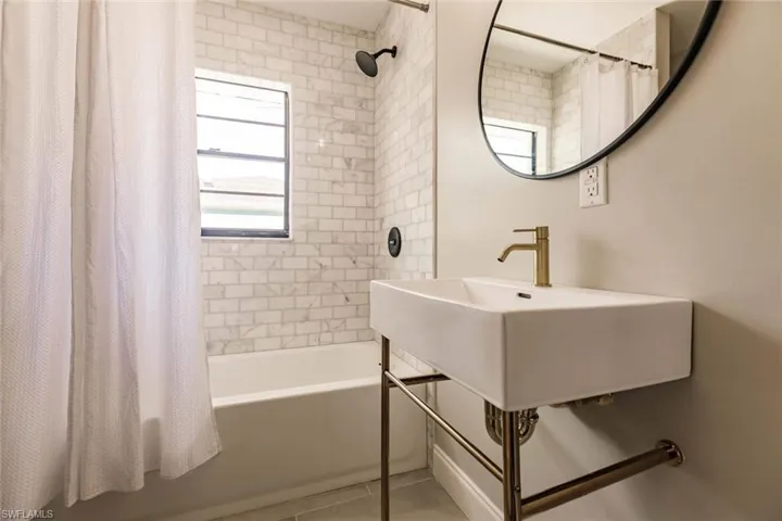 Bathroom with shower / bath combo with shower curtain and tile patterned flooring