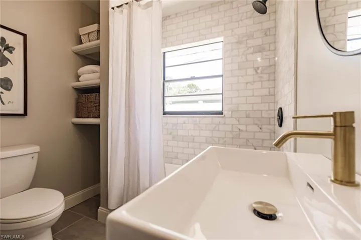 Full bathroom with a sink and dark tile patterned flooring
