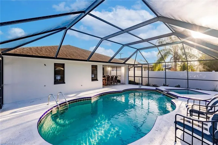 View of pool with a sunroom, a patio, a pool with connected hot tub, and a lanai