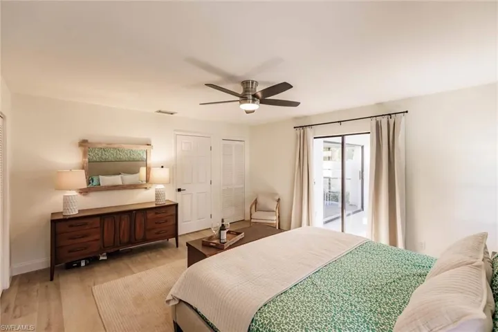 Bedroom featuring light wood-style floors, access to outside, ceiling fan, and multiple closets