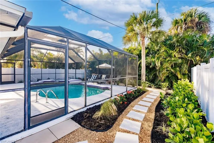 View of pool featuring a fenced backyard, glass enclosure, a sunroom, and a patio area