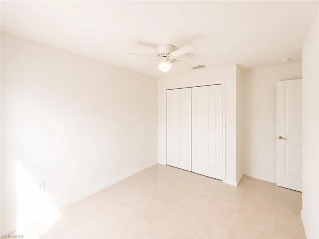 Neutral-toned tile flooring complements light walls in this versatile room