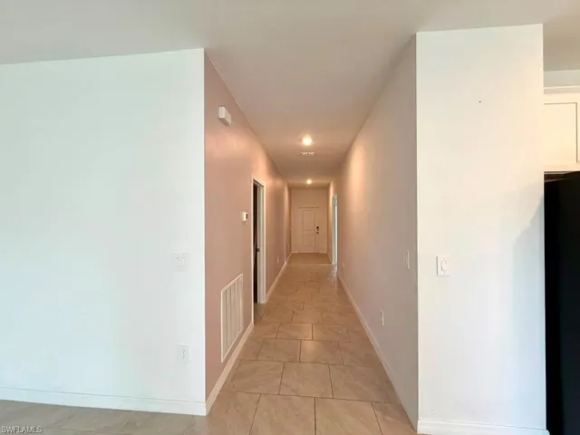 Hallway with tiled flooring and recessed lighting