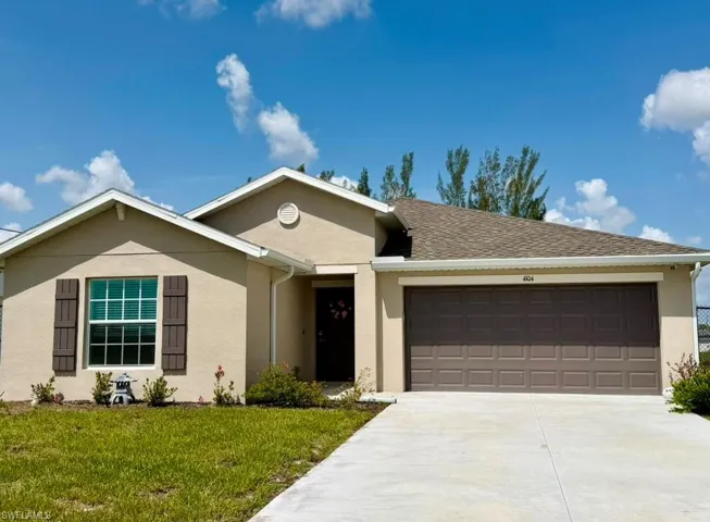 Contemporary stucco exterior with an attached garage, paved driveway, and decorative window shutters