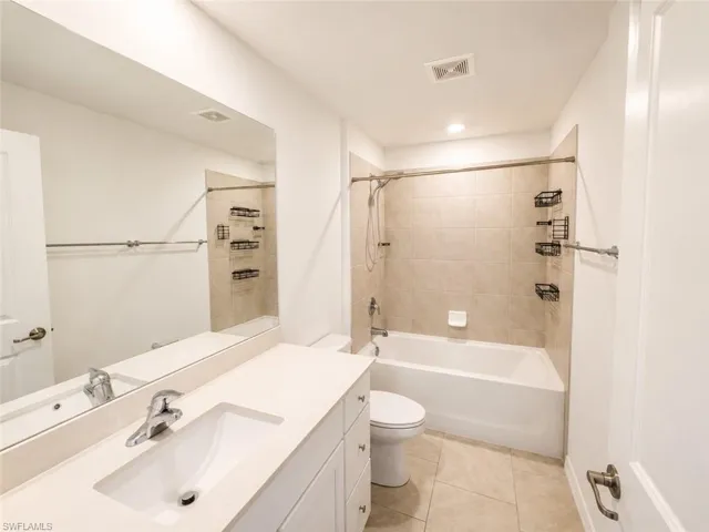 Bathroom featuring a white vanity with an integrated sink, polished chrome faucet, and a large wall-mounted mirror